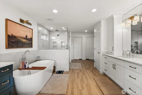 a spacious bathroom with a double vanity sink tub and mirror