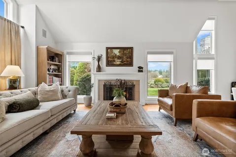 a living room with furniture a fireplace and a large window