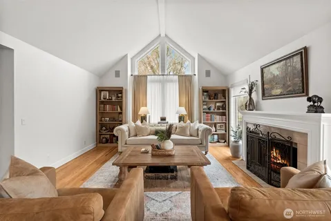a living room with furniture fireplace and a large window