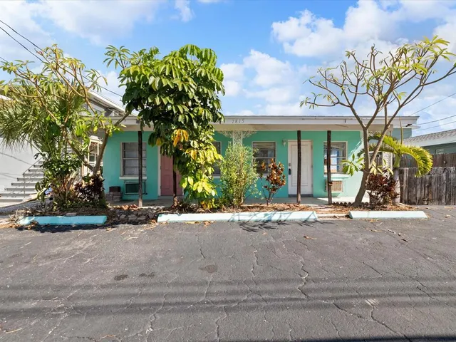 a couple of potted plants in front of brick house