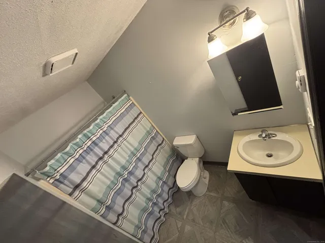 a bathroom with a sink toilet and mirror