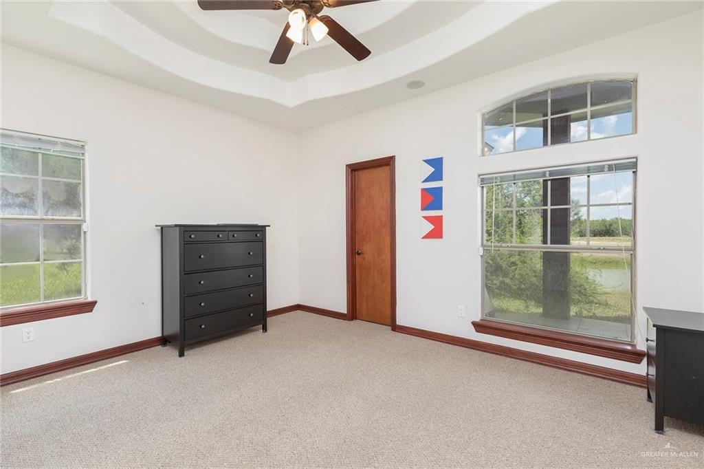 1213 Rhett Drive Pharr, TX 78577 - Photo 14 of 19 Spacious bedroom with tray ceiling, abundant natural light, and pond views.