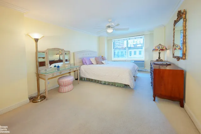 a bedroom with bed and a large window