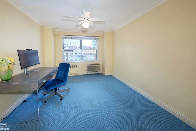 a view of a workspace with furniture and a window