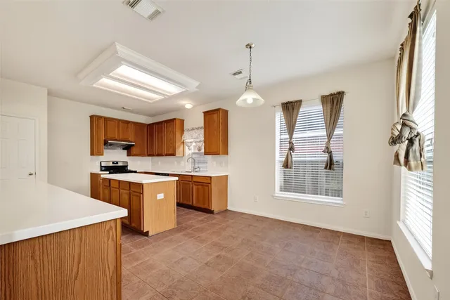 a open kitchen with cabinets a stove and a wooden floor