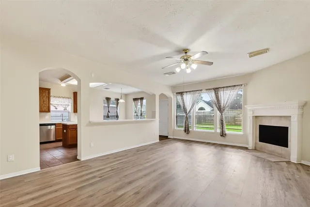wooden floor fireplace and windows in an empty room