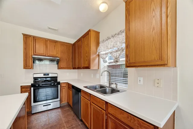 a kitchen with a sink a stove and cabinets