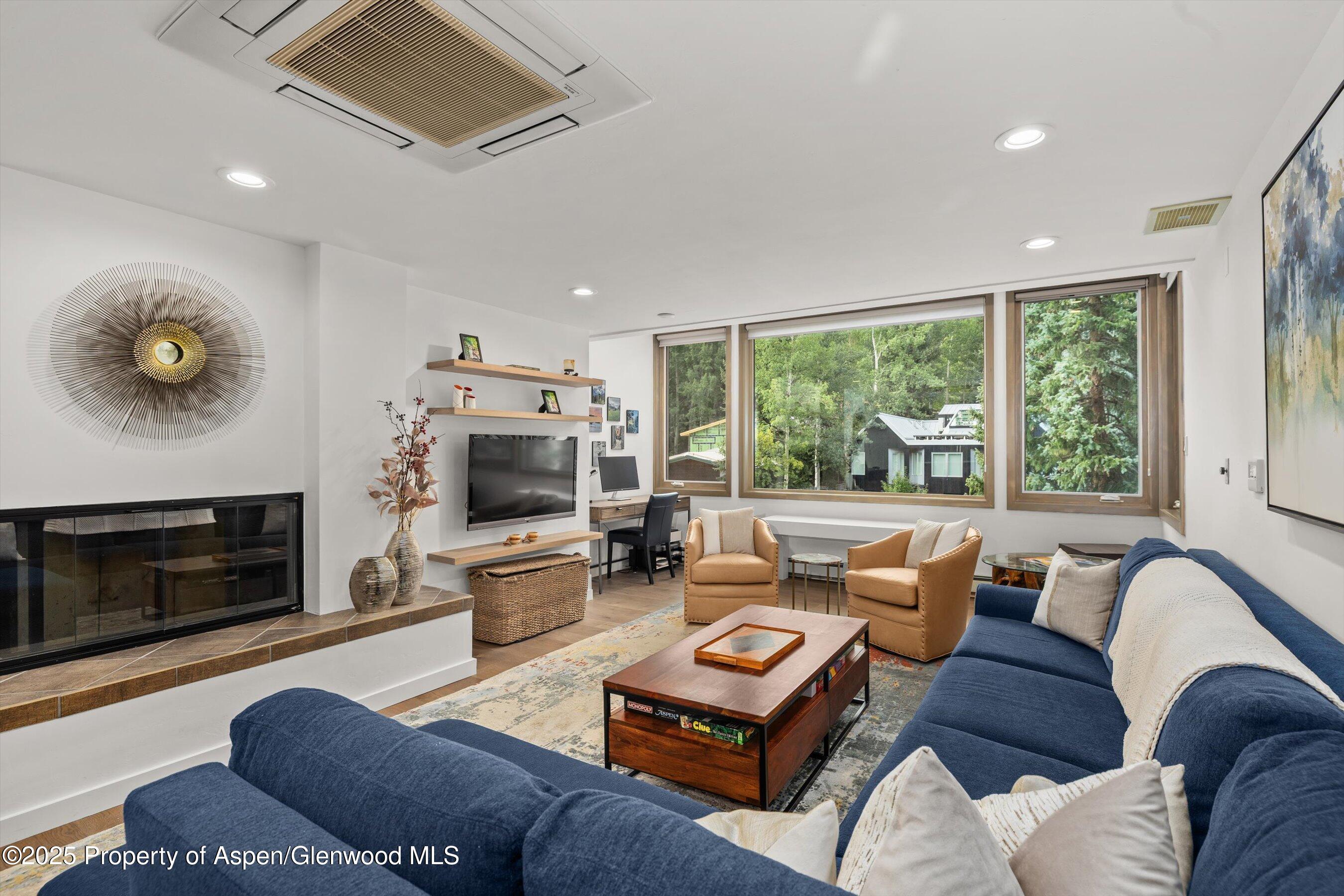 a living room with furniture a fireplace and a flat screen tv