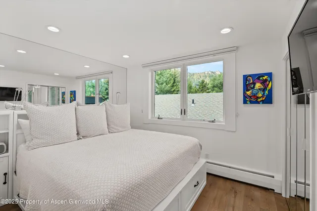 a bed room with a bed window and a flat screen tv