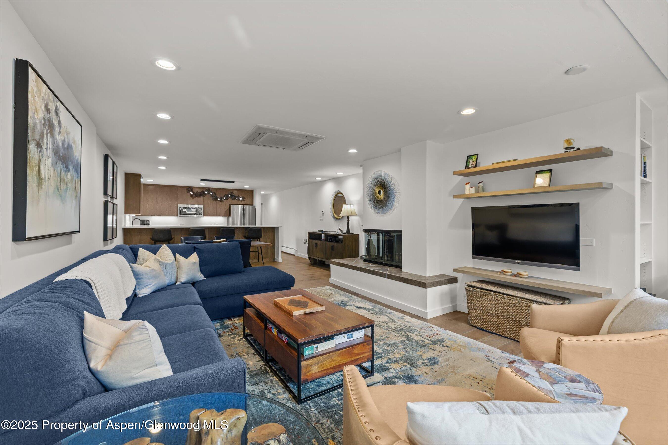 926 Waters Avenue, Unit 301 Aspen, CO 81611 - Photo 5 of 16 a living room with furniture and a flat screen tv