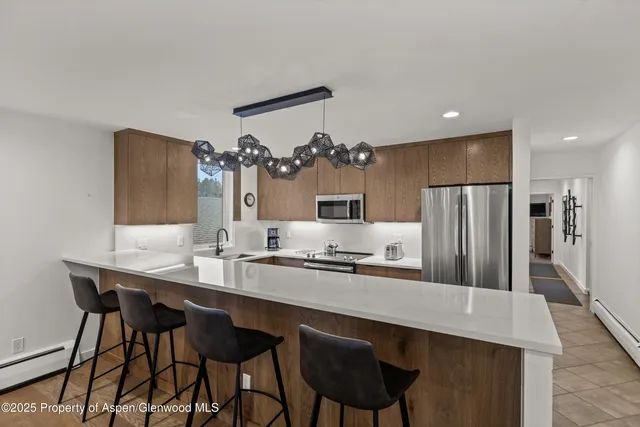 a kitchen with a table chairs refrigerator and microwave