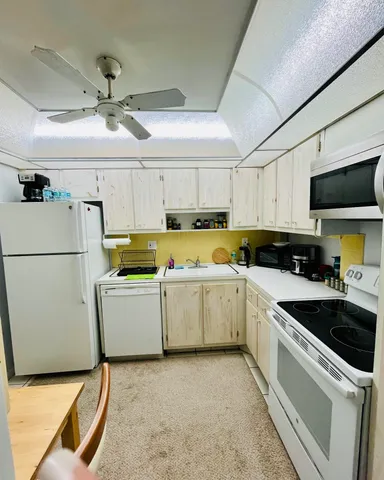 a kitchen with a sink a counter top space cabinets and stainless steel appliances