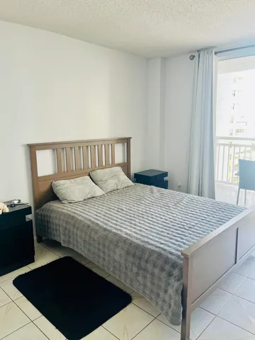 a bed sitting in a bedroom next to a window