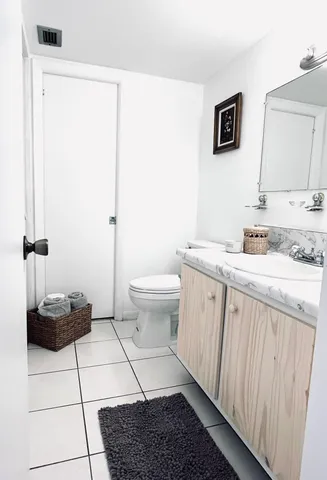 a bathroom with a granite countertop sink a toilet and mirror