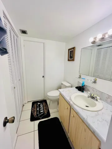 a bathroom with a sink a toilet a mirror and shower