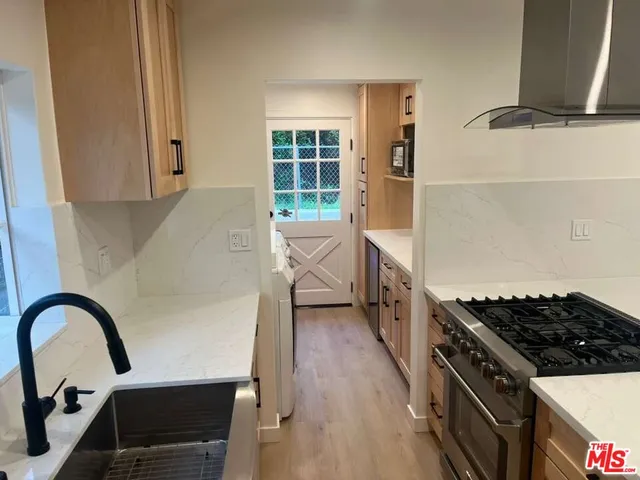 a kitchen with a stove a sink and a window