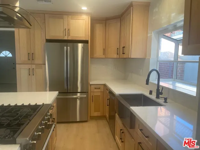a kitchen with stainless steel appliances granite countertop a refrigerator and a sink