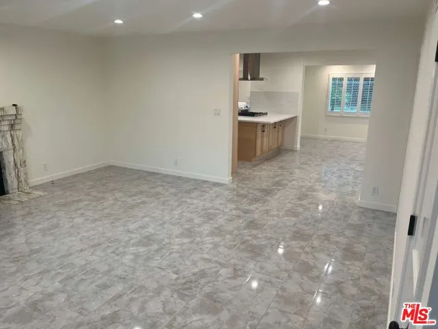 an empty room with a kitchen space sink and windows