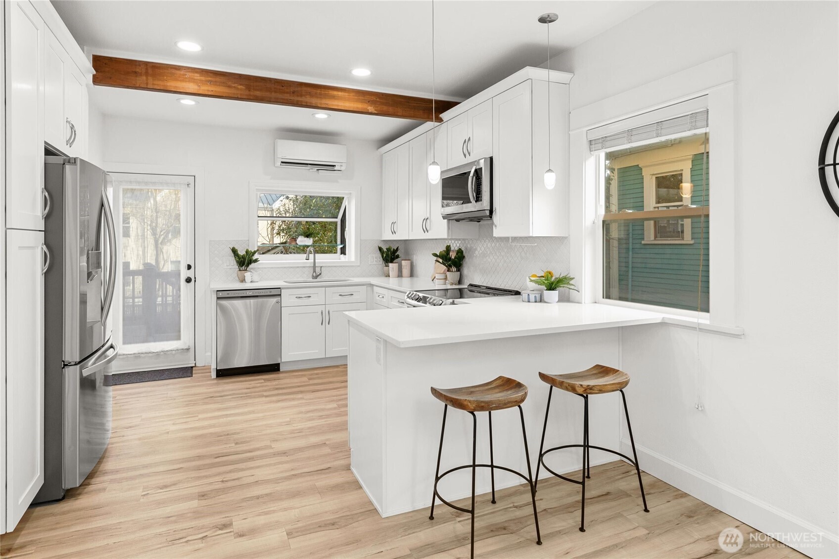 424 27th Avenue East Seattle, WA 98112 - Photo 9 of 36 a kitchen with stainless steel appliances a sink a stove a refrigerator cabinets and dining table