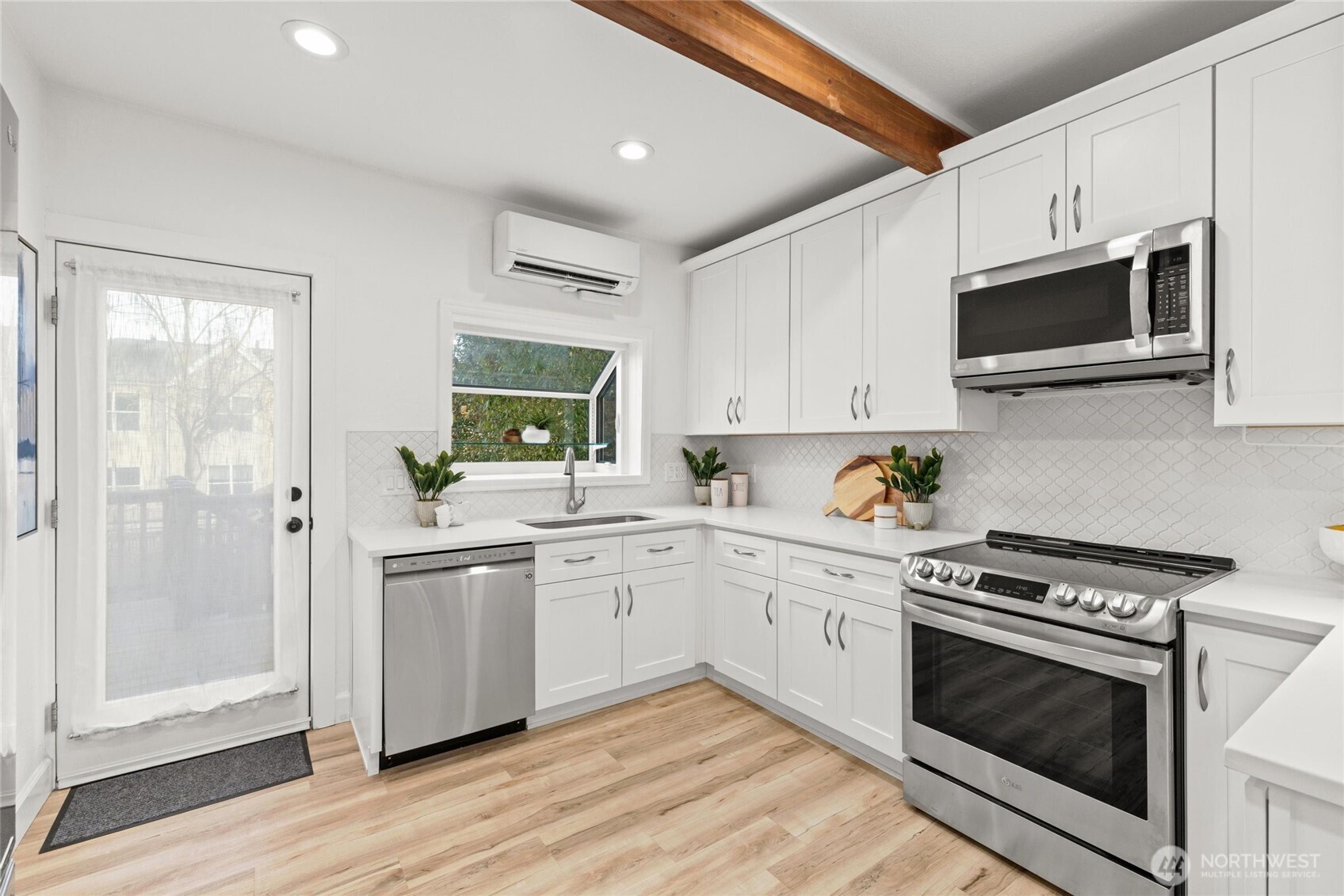 424 27th Avenue East Seattle, WA 98112 - Photo 10 of 36 a kitchen with stainless steel appliances granite countertop a stove a microwave and white cabinets