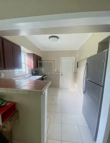 a kitchen with stainless steel appliances granite countertop a refrigerator and a stove