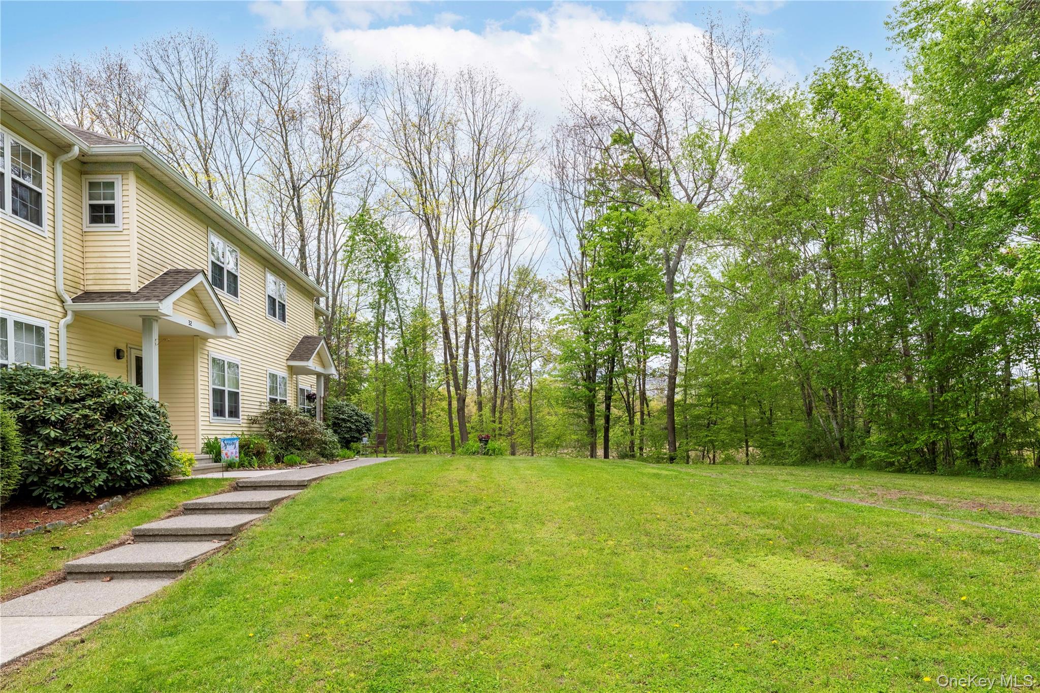 129 Stringham Road, Unit 31 LaGrangeville, NY 12540 - Photo 4 of 26 a view of a white house in front of a big yard with large trees