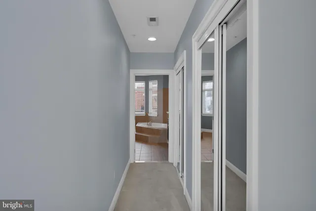 a view of a hallway with a livingroom and a bathroom with sink