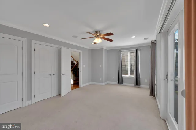 a view of a livingroom with a ceiling fan & entryway