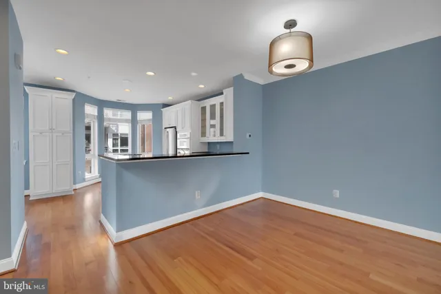 a view of a kitchen with wooden floor and a ceiling fan