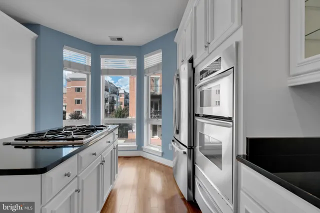 a kitchen with granite countertop a stove and a refrigerator