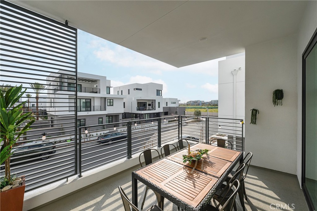2053 Peebler Way Tustin, CA 92782 - Photo 18 of 37 a balcony with a table and chairs and wooden floor