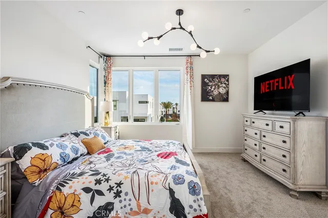 a bedroom with a bed a dresser and next to a window