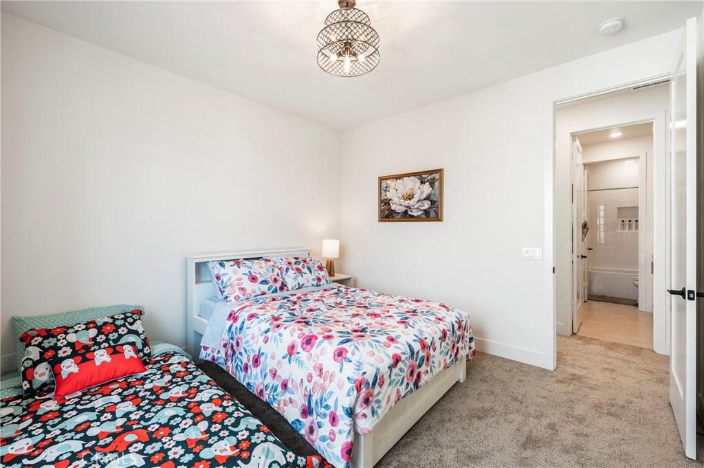 2053 Peebler Way Tustin, CA 92782 - Photo 32 of 37 a bedroom with bed and a chandelier