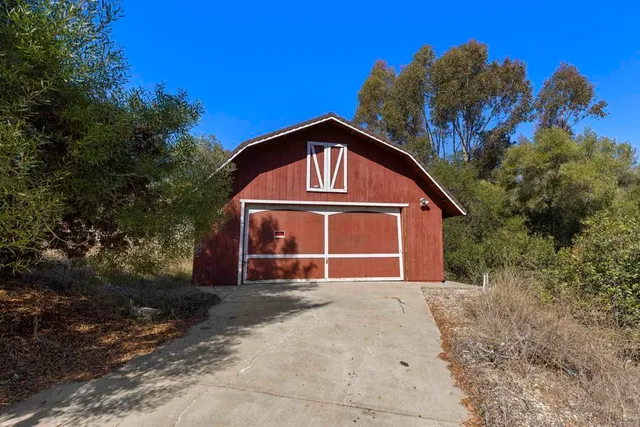 a view of a dry yard with wooden fence