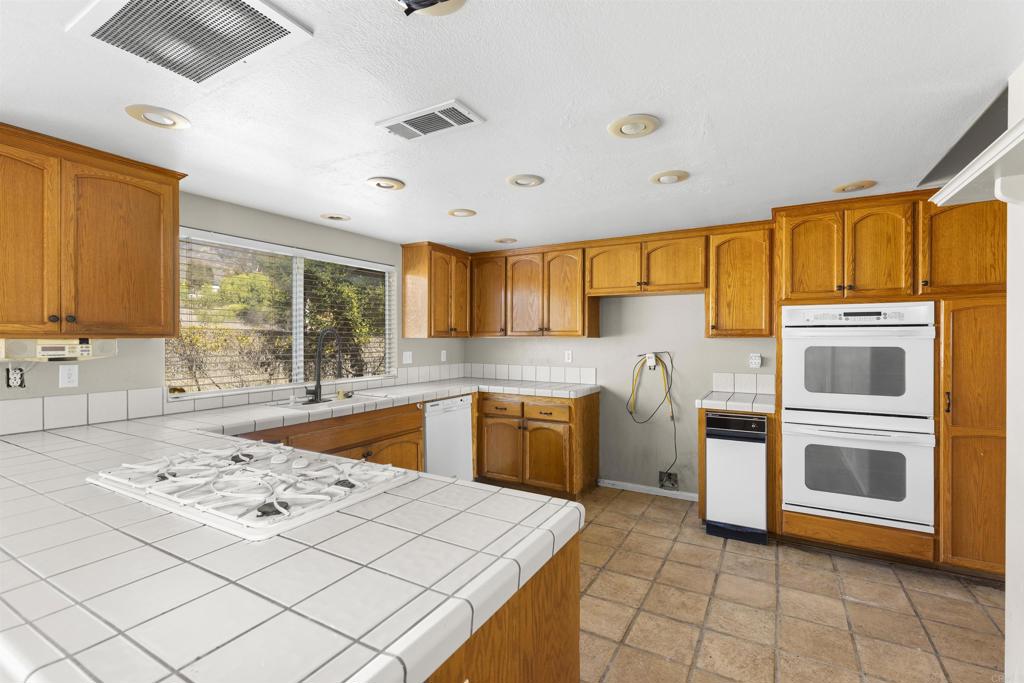 1007 Capra Way Fallbrook, CA 92028 - Photo 20 of 44 a kitchen that has a sink and a stove top oven