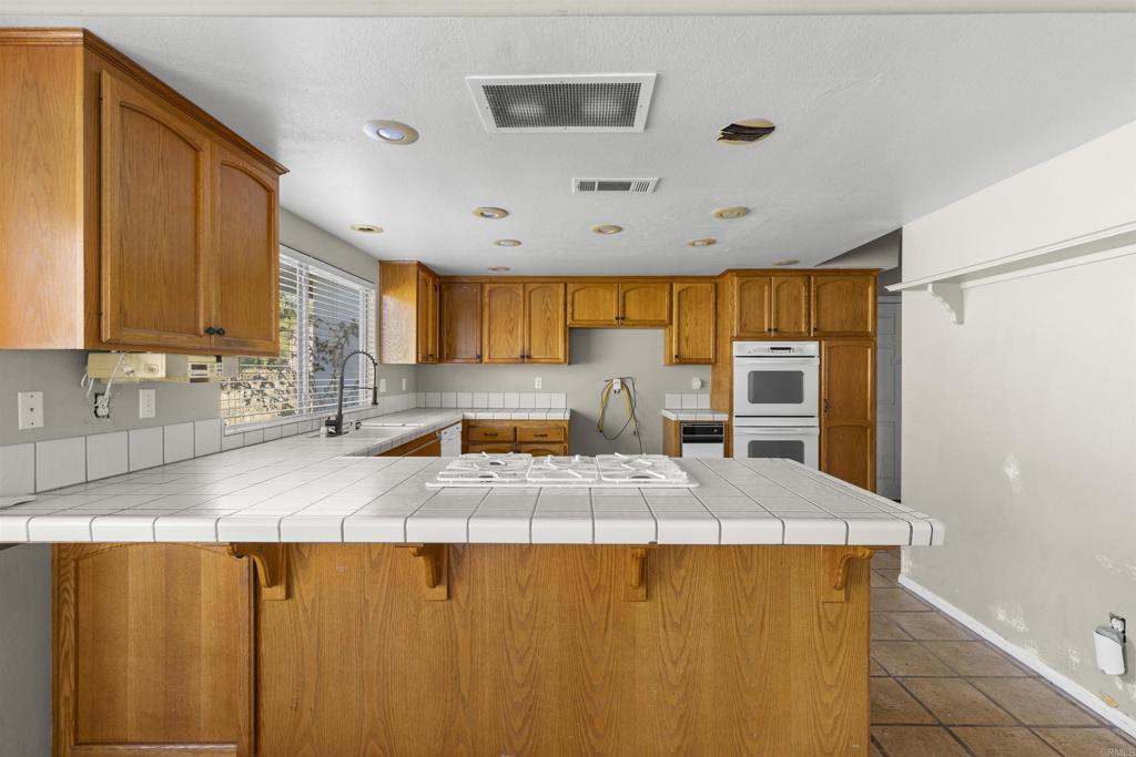 1007 Capra Way Fallbrook, CA 92028 - Photo 22 of 44 a kitchen with stainless steel appliances granite countertop a sink a stove and refrigerator