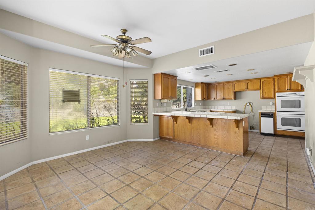 1007 Capra Way Fallbrook, CA 92028 - Photo 25 of 44 a large kitchen with stainless steel appliances granite countertop a sink window and cabinets