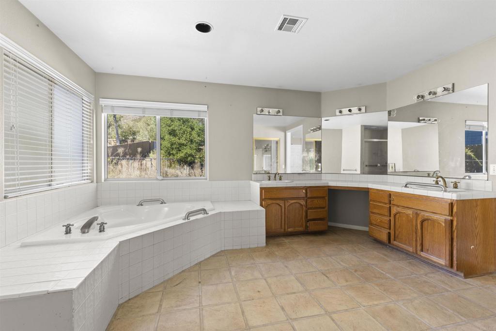 1007 Capra Way Fallbrook, CA 92028 - Photo 33 of 44 a large bathroom with a large tub and double vanity