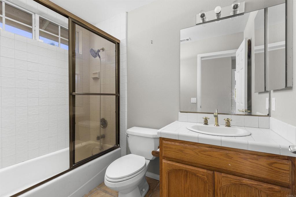1007 Capra Way Fallbrook, CA 92028 - Photo 39 of 44 a bathroom with a granite countertop sink toilet and shower