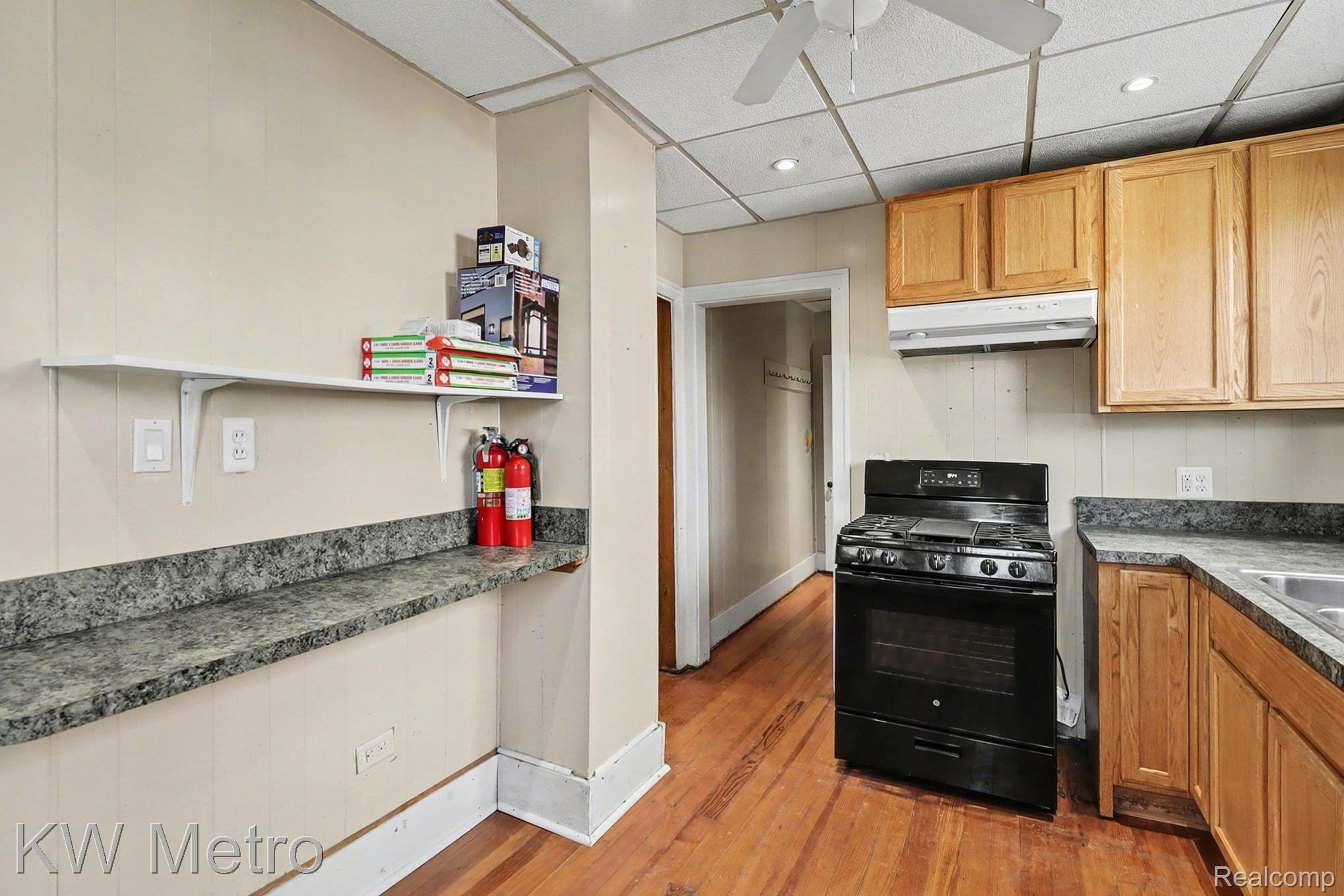 85 Walnut Street River Rouge, MI 48218 - Photo 10 of 20 Kitchen with a paneled ceiling, black range with gas cooktop, dark countertops, light wood finished floors, and ceiling fan