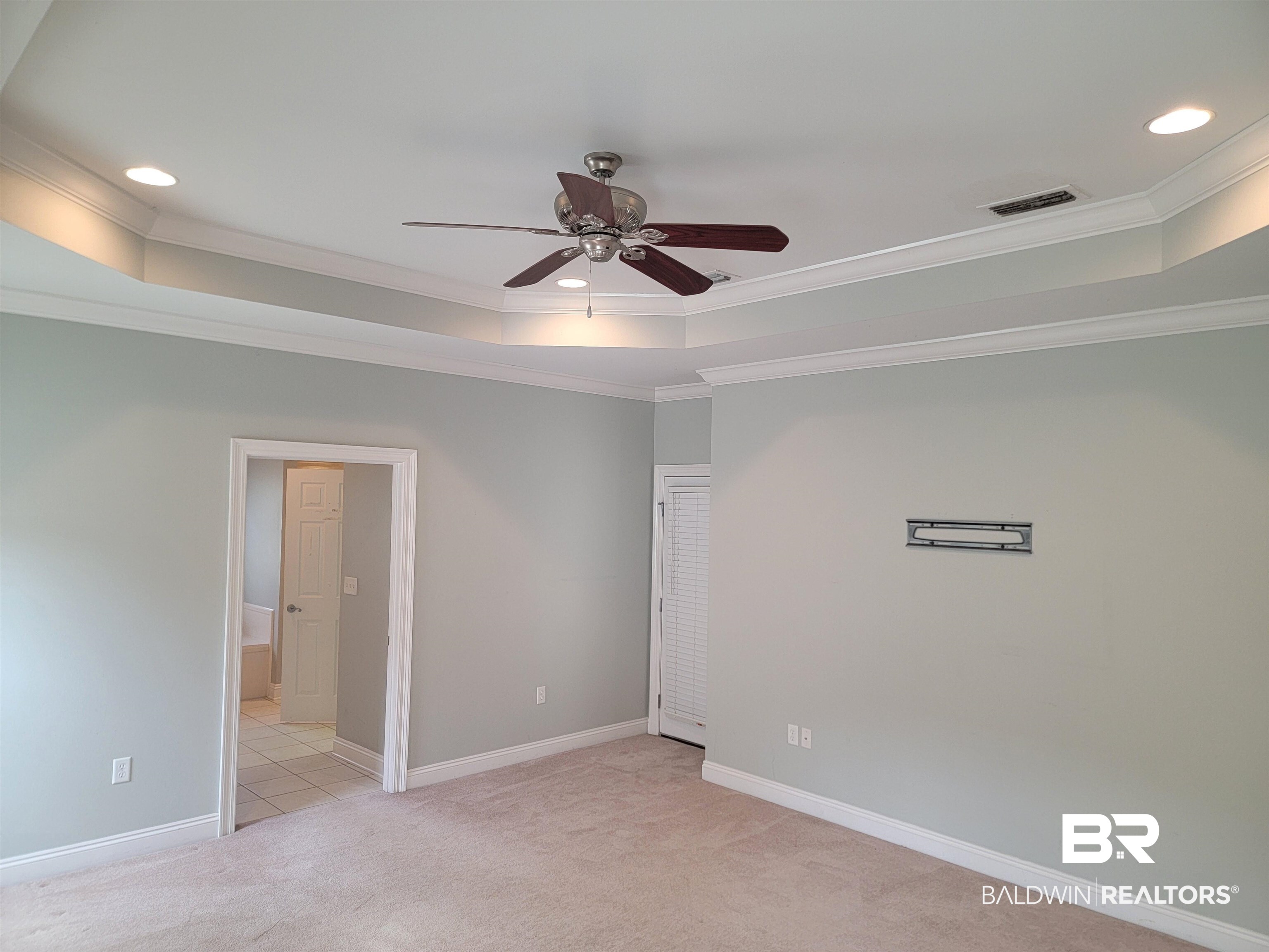 306 South Tee Drive Fairhope, AL 36532 - Photo 16 of 37 Carpeted spare room with ceiling fan, ornamental molding, and a tray ceiling