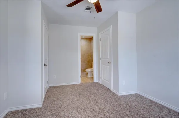 an empty room with ceiling fan and window