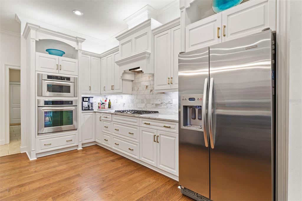 10257 Southwest 37 Place Gainesville, FL 32608 - Photo 15 of 44 a kitchen with stainless steel appliances kitchen island granite countertop a refrigerator and a stove top oven