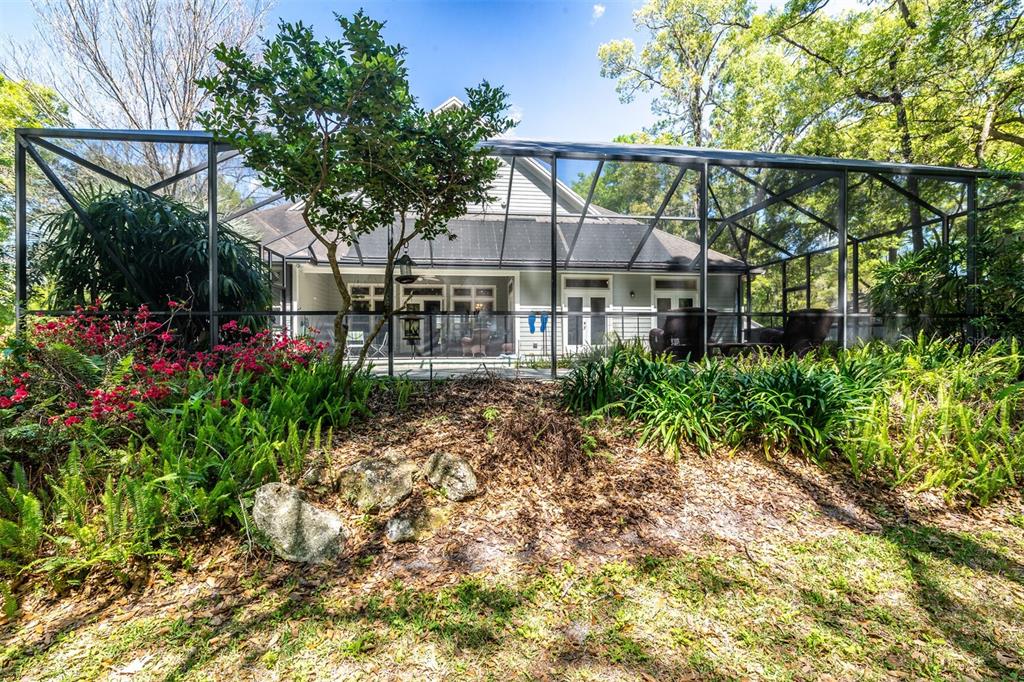 10257 Southwest 37 Place Gainesville, FL 32608 - Photo 40 of 44 a view of a house with large trees and plants next to a yard