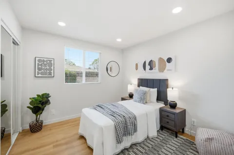 a bedroom with a bed and a potted plant
