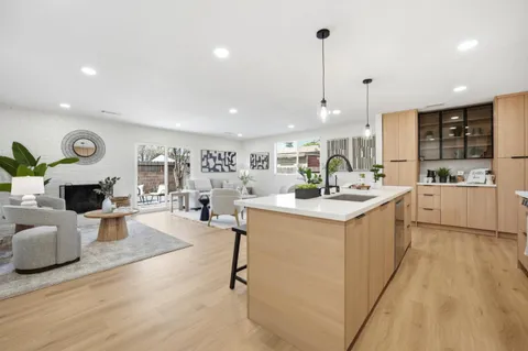 a kitchen with kitchen island granite countertop a sink cabinets and wooden floor