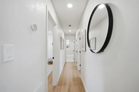 a view of a hallway with wooden floor and staircase