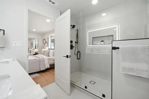 a bathroom with a tub shower and bedroom
