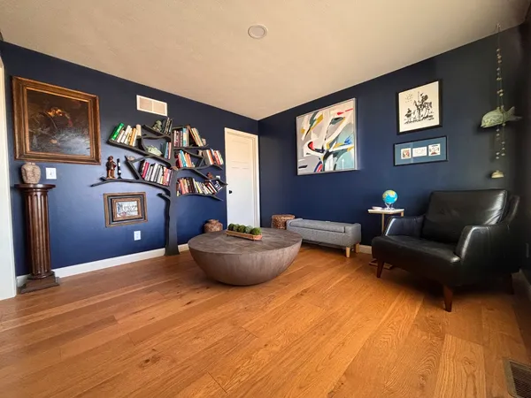 a living room with furniture and wall paintings