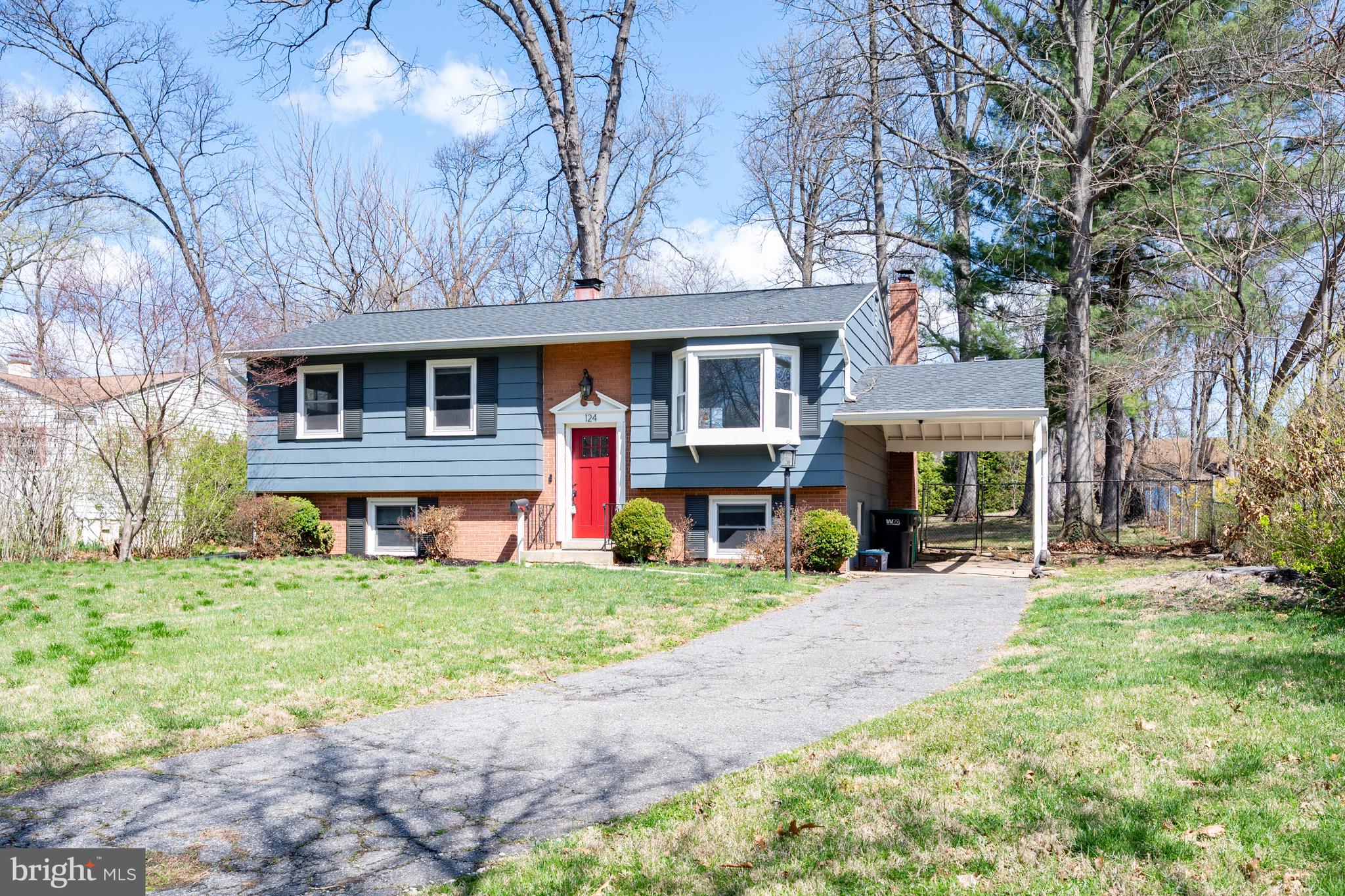 a front view of a house with a yard and trees